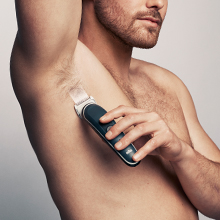Image of a man using the groomer to shave his armpit