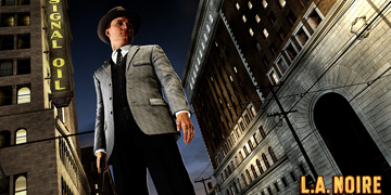 A man dressed in a suit and hat stands, looking down at the ground, holding a gun