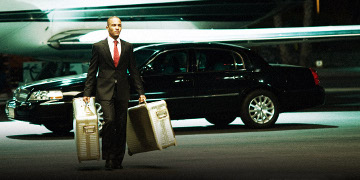 Ghost Walking Away From A Black Car Holding Two Big Metal Breifcases