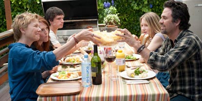 Family Sat Round A Table Outside Having Dinner