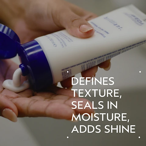 Image 2 - A hand squeezes white Aveda Brilliant Original Styling Creme from a tube with a blue cap into the palm of the other hand, with the tube showing 150 ml e, and large white text overlaid on the image states DEFINES TEXTURE, SEALS IN MOISTURE, ADDS SHINE. Image 3 - A before and after image shows a person with dark, curly, frizzy hair on the left, labeled BEFORE Unwashed Hair, and the same person with dark, smooth, straight hair on the right, labeled AFTER Results with Brilliant Shampoo, Conditioner, Damage Control Retexturing Gel, Anti-Humectant Pomade and Medium Hold Hair Spray and Brilliant™ Universal Styling Creme. Blow dried with brush. Image 4 - A dark green graphic features a central white circular area filled with pink flower petals, a white jasmine flower, and brown cloves, with the text BLISSFUL PURE-FUME AROMA and AN AROMATIC BLEND WITH JASMINE, ROSE, CERTIFIED ORGANIC CLOVE AND OTHER PURE FLOWER AND PLANT ESSENCES. Image 5 - A dollop of white cream with soft swirls sits on a white surface, casting a subtle shadow. Image 6 - A four-step hair care routine is presented on a dark green background, featuring a hand shampooing dark hair, a hand dispensing conditioner, a person spraying hair product, and a collection of Aveda Brilliant styling products, with the visible text reading HOW TO USE, 01 CLEANSE Brilliant™ Shampoo, 02 CONDITION Brilliant™ Conditioner, 03 PREP Brilliant™ Damage Control, and 04 STYLE Brilliant™ Anti-Humectant Pomade, Medium Hold Hair Spray and Universal Styling Crème. Image 7 - The image shows three white certification logos against a background of dark green leaves; the logos include a large V with the text 100% VEGAN, a B inside a circle with the text Certified B Corporation, and a leaping bunny with stars with the text Cruelty Free INTERNATIONAL.