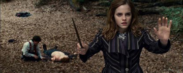 Hermione Casting A Spell Whilst Ron Lies On The Floor With Harry Knelt At His Side In The Background