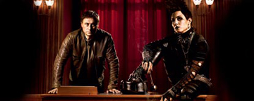 Mikael Blomkvist And Lisbeth Salander Stood Over A Desk