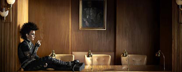 Lisbeth Salander Played By Noomi Rapace, Sat On a Desk