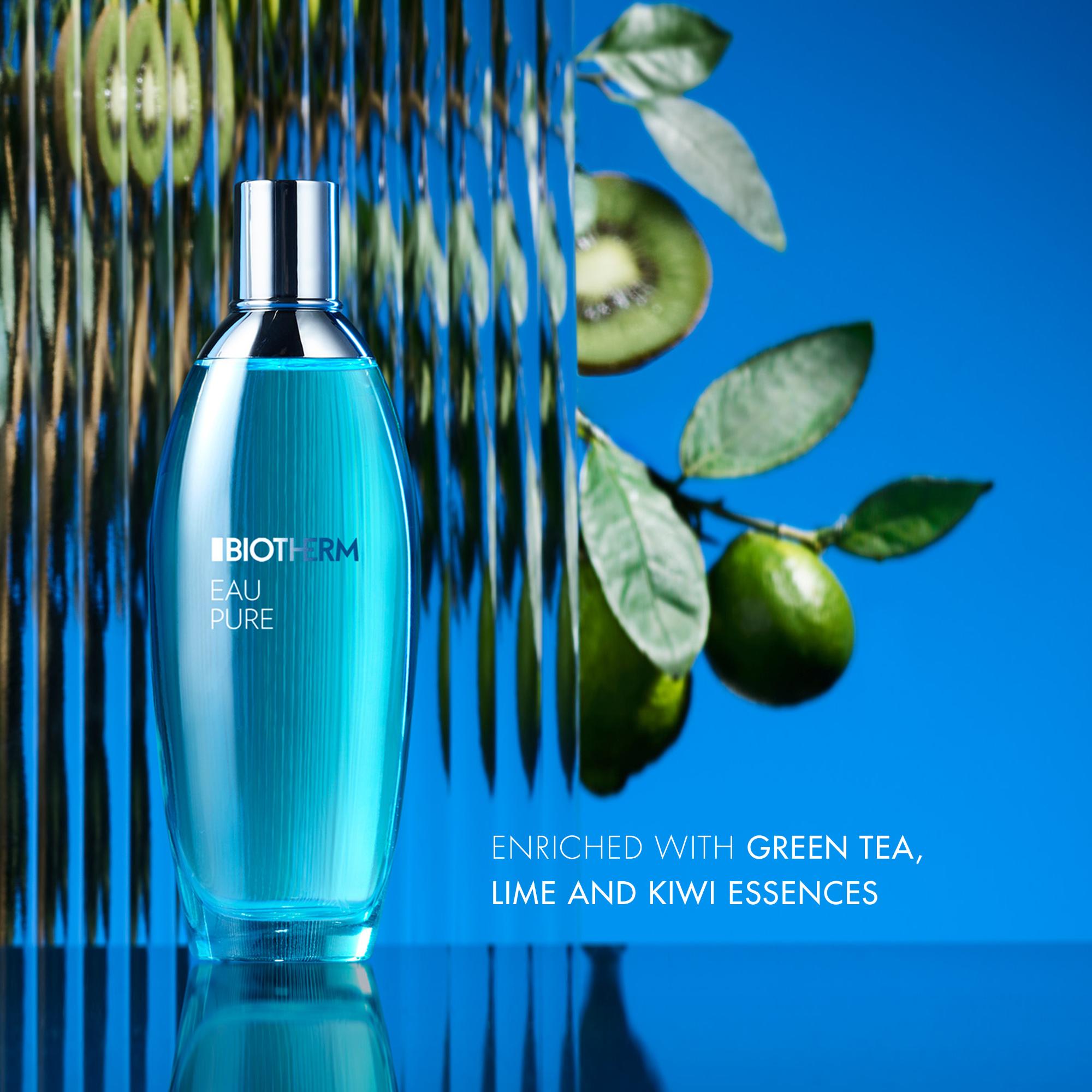 Image GIF1 - A blue perfume bottle labelled BIOTHERM EAU PURE stands on a reflective surface against a blue background, with vertical reflective panels partially obscuring kiwi slices and limes on branches behind it, and the text ENRICHED WITH GREEN TEA, LIME AND KIWI ESSENCES.
