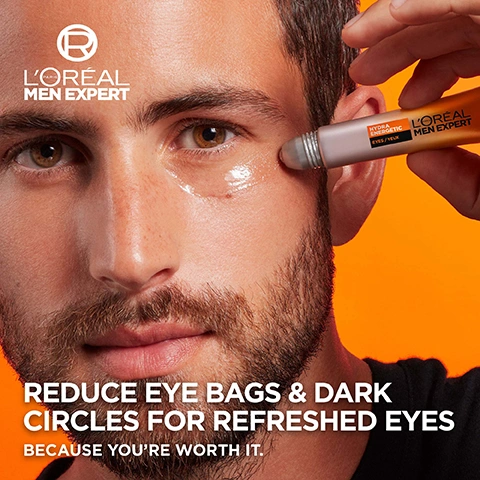 Image 1 - A man with a beard is applying a silver-tipped eye roller under his right eye, leaving a shiny clear product on his skin, against an orange background, with visible text LORÉAL PARIS MEN EXPERT logo, LORÉAL MEN EXPERT, HYDRA ENERGETIC, EYES / YEUX, REDUCE EYE BAGS & DARK CIRCLES FOR REFRESHED EYES, BECAUSE YOURE WORTH IT. Image 2 - The image displays a LOréal Men Expert Hydra Energetic Eye Roll-On tube on an orange background with a dab of the product, alongside text that reads HYDRA ENERGETIC EYE ROLL-ON, INSTANT & LONG-TERM EFFICACY, ANTI-EYE BAGS, ANTI-DARK CIRCLES, ANTI-FINE LINES, ENERGY BOOSTER, SUPER FRESH EFFECT, and on the tube itself, HYDRA ENERGETIC EYES / YEUX LORÉAL PARIS MEN EXPERT. Image 3 - A vertically split image features a glowing amber liquid substance with suspended particles on an orange background on the left, contrasting with a textured brown sphere of fine particles on a black background on the right, with the text POWERED BY [VITAMIN C*] [CAFFEINE] and *Vitamin C Derivative visible, along with a circular R logo. Image 4 - The image displays a three-step LOréal Men Expert Hydra Energetic skincare routine against an orange background with a reflective brown surface, showing an amber dropper bottle for serum, a grey and orange pump bottle for moisturizer, and a silver and orange tube with a rollerball for eye care, with visible text HYDRA ENERGETIC ROUTINE, STEP 1 SERUM, LOréal Paris Men Expert Hydra Energetic Vitamin C Shot Serum 10% Pure Vitamin C, STEP 2 MOISTURISER, LOréal Paris Men Expert Hydra Energetic Anti-Fatigue SPF 15 Moisturiser Vitamin C + UV Filters, STEP 3 EYE CARE, LOréal Paris Men Expert Hydra Energetic Eyes / Yeux, and a registered trademark symbol.
