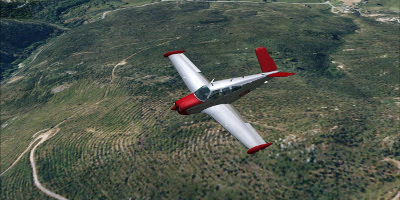 A small propellor-powered aircraft flies over some hills