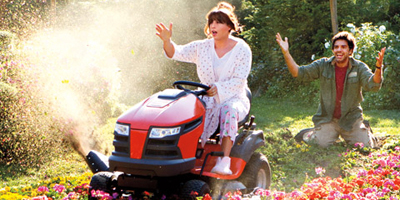 Jill Riding Lawnmower Over Flowers