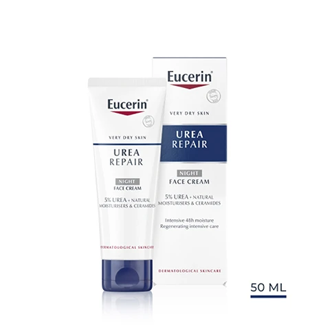 Image 1 - A tube of Eucerin Urea Repair Night Face Cream alongside its packaged box, both featuring blue and white branding, with visible text stating 5% UREA, NIGHT FACE CREAM, very dry skin, and dermatological skincare, and the box size labeled as 50 ML.
              Image 2 - A close-up of a woman’s face with cream applied to her cheek, accompanied by text that lists key benefits: intensive 48h moisture, regenerating intensive care, and reduces skin tightness.
              Image 3 - A hand holds a tube of Eucerin Urea Repair cream on the left, with text on the right stating Dry, tense, dehydrated skin, For face, and Night.
              Image 4 - A smooth, white cream blob with labels pointing to its key ingredients: 5% Urea, Ceramides, and Natural Moisturisers.
              Image 5 - Image features a blue background with the following text: Clinically proven Improves skins moisture and barrier function.
              Image 6 - Image shows three skincare products from Eucerin labeled as part of a recommended routine, with a lip balm on the left labeled as LIP CARE, a tube of day cream in the center labeled as DAY CREAM, and a tube of night cream on the right labeled as NIGHT CREAM, all under the heading Recommended Routine.