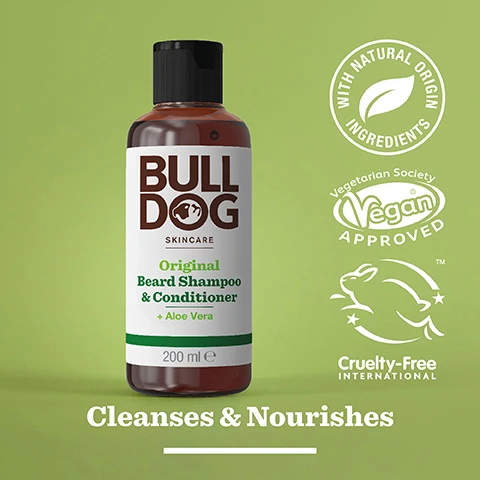 Image 2 - A brown bottle of Bulldog Skincare Original Beard Shampoo and Conditioner with a black cap, featuring text highlighting its natural ingredients, vegan approval, and cruelty-free certification, set against a light green background, with the phrase Cleanses & Nourishes displayed prominently.
              Image 3 - A close-up image of a translucent, green gel sitting on a smooth, white surface, featuring the text 92% Natural Origin, Unlock the true potential of natural origin ingredients, and Cleanse & Nourishes.
              Image 4 - A person is holding a bottle of beard shampoo labeled Bulldog Skincare for All Beard Types, with some product being dispensed into their other hand.
              Image 5 - A bottle of Bulldog Original Beard Shampoo & Conditioner sits on a bathroom countertop with a label indicating it is made from 97% recycled PCR plastic.
              Image 6 - Three Bulldog Skincare products for beards are displayed on a shelf, including a bottle of beard oil, a bottle of beard shampoo and conditioner, and a jar of beard balm, with the text Tame Your Beard at the bottom.