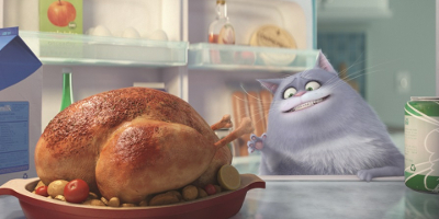 Still from the film showing a cat grinning while looking at a cooked chicken.