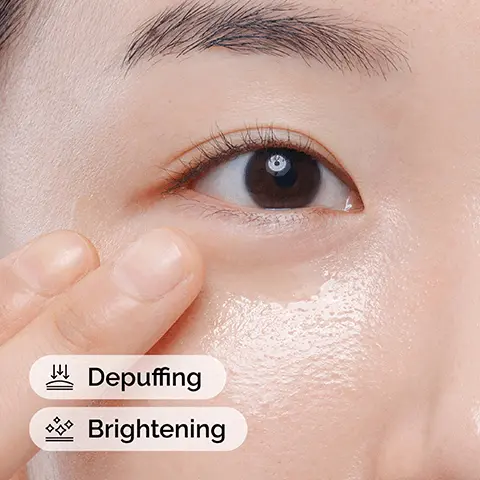 Image 1 - A close-up view of a persons eye with a hand gently touching under the eye, accompanied by text labels that read Depuffing and Brightening.
              Image 2 - Image depicts three skincare products from The Ordinary arranged in a row: Squalane Cleanser labeled as prep for cleansing skin and removing makeup, Caffeine Solution 5% + EGCG labeled as treat for reducing under-eye puffiness and dark circles, and Natural Moisturizing Factors + HA labeled as seal for supporting the skin barrier, with additional text stating Ascorbyl Glucoside Solution 12% brightens and balances uneven skin tone.
              Image 3 - A close-up image of a transparent liquid flowing down, with text on the left side stating reduces the look of puffiness, reduces the look of dark circles, and improves the look of skin luminosity.