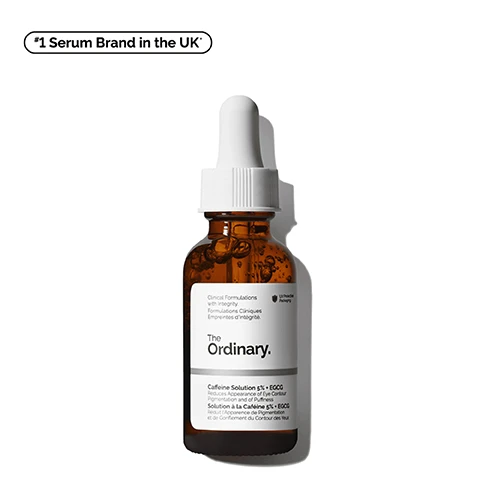 Image 1 - A brown glass bottle with a dropper lid contains a serum labeled The Ordinary Caffeine Solution 5% + EGCG, with text indicating it reduces the appearance of eye contour pigmentation and puffiness, along with a note showing it as the #1 Serum Brand in the UK.
              Image 2 - A close-up image of a golden liquid flowing from a transparent bottle with text beside it listing benefits: reduces the look of puffiness, reduces the look of dark circles, improves the look of skin luminosity.
              Image 3 - A close-up of a person applying a skincare product under their eye, showing healthy skin, with text labels for Depuffing and Brightening visibly displayed.
              Image 4 - Close-up of a translucent gel with bubbles, labeled with key ingredients for Caffeine Solution 5% + EGCG, including descriptions for Caffeine and Epigallocatechin gallatyl glucoside (EGCG).
              Image 5 - An image displaying a skincare regimen with three products labeled as PREP, TREAT, and SEAL, including Squalane Cleanser, Caffeine Solution 5% + EGCG, Ascorbyl Glucoside Solution 12%, and Natural Moisturizing Factors + HA, with descriptions for each product detailing their benefits for brighter skin.