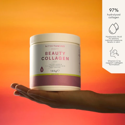 A hand holds a white jar of Myvitamins Beauty Collagen powder with the label Myvitamins Beauty Beauty Collagen 10g Collagen & 120mg Hyaluronic Acid Per Serving 15 Servings 180g e Lemon and Lime Flavour and side text 97% hydrolysed collagen Hyaluronic Acid to restore natural moisture levels in skin Vitamin C to support collagen formation.