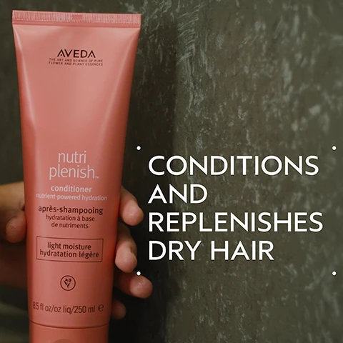 Image 2 - A hand holds a pink Aveda Nutriplenish conditioner tube against a dark, textured background, with visible text on the tube reading AVEDA THE ART AND SCIENCE OF PURE FLOWER AND PLANT ESSENCES nutri plenish™ conditioner nutrient-powered hydration après-shampooing hydratation à base de nutriments light moisture hydratation légère 8.5 fl oz /oz liq /250 ml e, and large white text next to it that says CONDITIONS AND REPLENISHES DRY HAIR. Image 3 - A split image shows a smiling woman with long dark wavy hair, with the left side depicting her hair before treatment looking somewhat dull, and the right side showing her hair after treatment looking smooth, shiny, and voluminous, alongside the visible text BEFORE, AFTER, Unwashed Hair, and Results with Nutriplenish™ Shampoo and Conditioner: Light Moisture, Daily Moisturizing Treatment, Styling Treatment Foam, Multi-Use Hair Oil and Wooden Paddle Brush. Blow dried with round brush. Image 4 - A dark green background with an abstract circular image of swirling red, yellow, and brown liquid, showing text SUPERFOOD COMPLEX, POMEGRANATE SEED OIL, COCONUT OIL, MANGO BUTTER, Hydrates and replenishes dry, depleted hair, and Lorem Ipsum. Image 5 - The image displays a four-step hair care routine titled HOW TO USE, featuring step 01 CLEANSE nutriplenish Shampoo Light Moisture with an accompanying image of hands washing hair with lather, step 02 CONDITION Nutriplenish Conditioner Light Moisture with an image of white conditioner being squeezed from an orange tube labeled 8.5 fl oz liq/250 ml e AVEDA nutriplenish into a hand, step 03 TREAT Nutriplenish Daily Moisturizing Treatment with an image of a woman applying product to her long, dark hair, and step 04 STYLE Nutriplenish Styling Treatment Foam & Multi-Use Hair Oil with an image of white foam being dispensed from an orange bottle labeled AVEDA nutriplenish onto a hairbrush. Image 6 - Two creamy white product swatches, one smooth and one ridged, overlapping on a white background with subtle shadows. Image 7 - Dark green leaves and a red plant form the background for three white certification logos, which read 100% VEGAN with a V symbol, Certified B Corporation with a B symbol, and Cruelty Free International with a leaping bunny symbol.