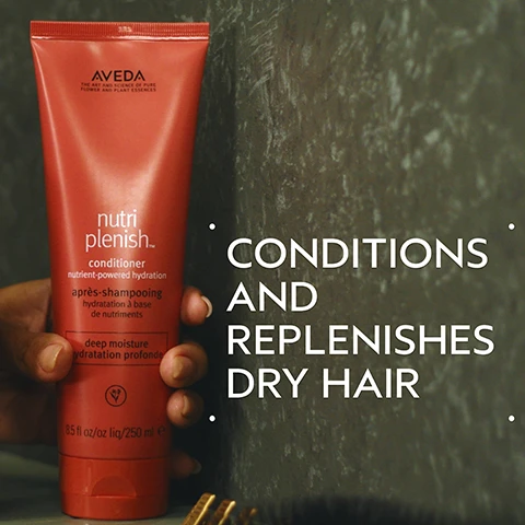 Image 2 - A hand holds a red-orange tube of Aveda Nutriplenish conditioner, featuring the text Aveda The Art and Science of Pure Flower and Plant Essences, nutri plenish™ conditioner nutrient-powered hydration, après-shampooing hydratation à base de nutriments, deep moisture hydratation profonde, 8.5 fl oz/oz liq/250 ml e, next to large white text that reads CONDITIONS AND REPLENISHES DRY HAIR. Image 3 - A before and after image shows a woman with curly hair; the before image has dry, less defined curls, while the after image displays hydrated, shiny, and well-defined curls. The text reads BEFORE, AFTER, Unwashed Hair, and Results with Nutriplenish ™ Shampoo and Conditioner: Deep Moisture, Nutriplenish Leave-In Conditioner, Curl Gelee, Replenishing Overnight Serum and Wooden Paddle Brush. Blow dried with diffuser attachment. Image 4 - A dark green background features a large central circular image of swirling red, gold, and brown liquids, evoking rich oils, with the text SUPERFOOD COMPLEX, POMEGRANATE SEED OIL, COCONUT OIL, MANGO BUTTER, and Hydrates and replenishes dry, depleted hair. Image 5 - Two distinct swatches of white and off-white cosmetic creams, one thick and wavy, the other thinner and spread, are depicted with various clear liquid droplets on a plain white background. Image 6 - A step-by-step hair care guide displays a person washing hair, hands dispensing white conditioner from a tube, and hands dispensing clear gel from a bottle, with the text: HOW TO USE 01 CLEANSE Nutriplenish™ Shampoo: Deep Moisture 02 CONDITION Nutriplenish™ Conditioner: Deep Moisture & Leave-In Conditioner 03 STYLE Nutriplenish™ Curl Gelee & Replenishing Overnight Serum. Image 7 - Three white certification logos are displayed against a background of dark green leaves with a red plant stem, showing 100% VEGAN, Certified B Corporation, and Cruelty Free INTERNATIONAL.