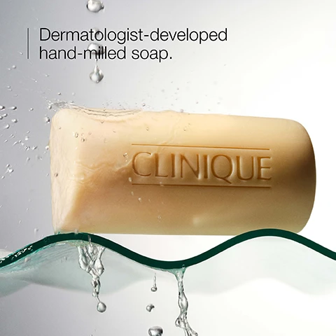 Image 1 - A bar of beige soap labeled CLINIQUE is shown partially submerged in water with droplets splashing around it, accompanied by the text Dermatologist-developed hand-milled soap.
              Image 2 - Image shows two bars of Clinique Facial Soap, one yellow labeled Clinique Facial Soap - Dry with the text Dermatologist-developed soap for dry skin and one beige labeled Clinique Facial Soap - Oily with the text Dermatologist-developed soap for oily skin.