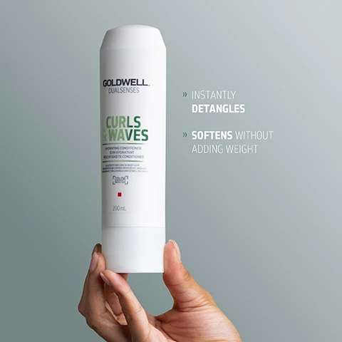 Image 1 - A hand holds a white Goldwell Dualsenses Curls & Waves Hydrating Conditioner 200mL bottle, and text to its right reads: INSTANTLY DETANGLES SOFTENS WITHOUT ADDING WEIGHT. Image 2 - A white bottle of Goldwell Dualsenses Curls & Waves Hydrating Conditioner is displayed with three drops of blue product and features text: GOLDWELL DUALSENSES CURLS & WAVES HYDRATING CONDITIONER SOIN HYDRATANT FEUCHTIGKEITS-CONDITIONER ELASTICITY FOR CURLS & WAVES ELASTICITE POUR CHEVEUX BOUCLÉS ET ONDULÉS ELASTIZITÄT FÜR LOCKEN & WELLEN 200mL BLENDED WITH MICROPROTEC COMPLEX that distributes essential care ingredients quickly and evenly MILK-PROTEIN that helps to improve elasticity with bouncing effect, for hydrated and reactivated curls With BUILT-IN COLOR PROTECTION. Image 3 - A white Goldwell Dualsenses Curls & Waves Hydrating Conditioner bottle is displayed, with visible text on the label including Soin Hydratant, Feuchtigkeits Conditioner, Elasticity for curly & wavy hair, Elasticite pour cheveux boucles & ondules, Elastizitaet fuer lockiges und welliges Haar, Color, and 200mL, and below the bottle, a QR code along with text: ClimatePartner certified product climate-id.com/PBNVQ3 CO2 measure reduce contribute.