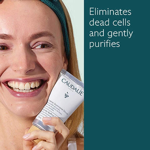 Image 1 - A smiling woman holds a tube of Caudalie skin product close to her face, with text beside her that reads eliminates dead cells and gently purifies.
              Image 2 - A tube of Caudalie Gentle Buffing Cream is placed on a textured surface, surrounded by a green grape and highlighting ingredients: Jojoba microbeads for cleansing and exfoliating, Grapeseed oil for nourishment, and Honey for softening, with the tube labeled Crème Gommante Douce and showing the volume as 75 mL.
              Image 3 - Image shows two skincare products from Caudalie: a light green tube labeled Deep Cleansing Exfoliator with the text Deeply purifies, Volcanic sand microbeads, All skin types and a dark green tube labeled Buffing Cream with the text Gently purifies, Jojoba microbeads, Sensitive skin.
              Image 4 - A hand is holding a tube of Caudalie skincare product while squeezing out a small amount onto the palm of another hand, with the text Apply to damp skin 1-2 times a week visible.