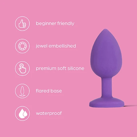 Image 1 - A purple silicone butt plug with a flared base and jewel embellishments on a pink background, accompanied by icons indicating features including beginner friendly, premium soft silicone, and waterproof.
              Image 2 - A purple, tapered bulb with a smooth texture on a pink background, accompanied by text that reads Beginner friendly Petite bulb with a tapered tip making it easy for insertion.
              Image 3 - A hand holding a purple silicone product shaped like a goblet against a pink background, with text that reads Premium soft silicone Made from hypoallergenic silicone and is 100% body-safe.
              Image 4 - A purple object with a flared base is shown against a pink background, accompanied by the text Flared base for safe, secure play and easy removal.
              Image 5 - A purple jewel-embellished item with a rounded tip and a base, featuring a large clear jewel, on a pink background with the text Jewel embellished Add a touch of glamour to play with 3 interchangeable coloured jewels.