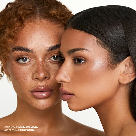 Image 5 - Two women with glowing skin, one with freckles looking forward and the other in profile, with text that reads JADE WEARS CARAMEL GLOW SOFIA WEARS SAND GLOW. Image 6 - A gold-capped cosmetic bottle with a thick stream of tan liquid pouring out, alongside instructions that read: HOW TO USE STEP 1 Start with clean, prepped skin. Use after Underglow Blurring Primer for a post-facial glow. STEP 2 Apply a small amount of the Radiance Booster using your fingertips. You can also mix it into your foundation for a softer, blended finish. STEP 3 For extra glow, layer under the Super Smoother Blurring Skin Tint to achieve that lit-from-within look. Image 7 - The image displays swatches of different foundation shades with three text boxes describing product ingredients and benefits: VITAMIN C: An antioxidant that helps boost skin radiance, SQUALANE & SHEA BUTTER: Helps nourish skin and lock in moisture, and LENTIL FRUIT EXTRACT: Helps smooth the look of skin. Image 8 - A woman with radiant skin and glossy lips poses with her hand under her chin, alongside a list of product benefits including KEY CLAIMS SMOOTH APPLICATION With Oleo-Gel complex to smooth seamlessly LUMINIZER PEPTIDES Create flawless transparency for perfected skin QUICK & EASY Apply with fingertips for full-face base coverage 100% VEGAN Totally vegan and cruelty free formula. Image 9 - The image displays four customer reviews with five-star ratings, set against a background of swiped beige foundation product. The reviews state: Absolutely love this...light coverage with a gorgeous healthy glow, easy to apply & lasts all day!! Buildable colour if you need a bit more for evening too - Kelly A. Love this product, gives you a lovely radiant glow, makes you look like you have natural highlighter and not too heavy on the skin. Use Iconic radiance booster all the time I have tried a few others in the past but nothing comes close to this it has the right name as it gives your skin a Radiance Boost...just Fabulous. Wow this really is a game changer. I wear this on its own or under a light foundation. This really does light up the skin and make it look super dewy without looking greasy.