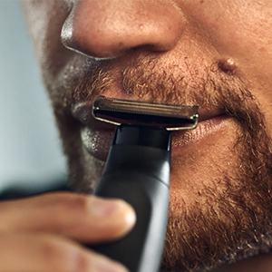 Image of a man using the trimmer on his moustache