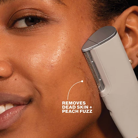 Image 1 - A close-up of a persons cheek as a facial hair removal device is used, with removed dead skin and peach fuzz visible, and text that reads REMOVES DEAD SKIN + PEACH FUZZ. Image 2 - A close-up shot of a razor blade with a fine, textured safety cage, accompanied by text that reads MICROFINE EDGE™ Ultimate precision, Closer contact with skin, Upgraded safety cage. Image 3 - A split image of a womans face shows a before and after comparison, with the left side labeled BEFORE highlighting dull + fuzzy skin on the cheek and jawline, and the right side labeled AFTER highlighting smooth + defined skin on the cheek and jawline. Image 4 - A split image of a womans face shows a Before comparison on the left with areas highlighted as dull + fuzzy, and an After comparison on the right with the same areas highlighted as smooth + glowing. Image 5 - A close-up of a persons face with smooth skin, featuring visible text: 100% saw instant improvement in skin texture*, 97% had less visible fine lines + wrinkles**, 94% showed improvement in discoloration + dark spots **. *Consumer panel survey using LUXE+ 1x, **Consumer panel survey after 4 weeks.