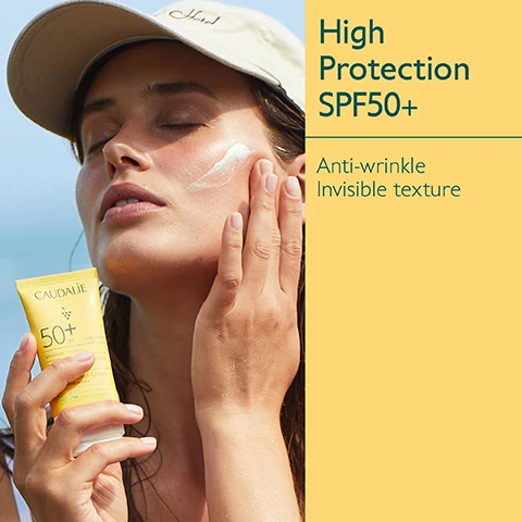 Image 1 - A woman applies sunscreen to her face while holding a tube of Caudalie High Protection SPF 50+, which has visible text that reads High Protection SPF50+ Anti-wrinkle Invisible texture.
              Image 2 - A tube of CAUDALIE sunscreen with SPF 50+ is shown beside green grapes and a banana peel, highlighting its ingredients: Grapeseed polyphenols and Vitamin E as antioxidants, with text indicating it offers very high protection.
              Image 3 - Image shows a collection of sun protection products from Caudalies Vinosun Protect line, including a spray, cream, sun water, lightweight cream, and stick, all displayed against a yellow background with visible labels indicating their SPF ratings.
              Image 4 - Image compares two sunscreen products: a High Protection Cream with a yellow and white tube labeled 50 on the left, and a Very High Protection Lightweight Cream with a yellow tube labeled 50+ on the right, with check marks indicating features such as cream texture, before sun exposure, sweet summer scent for the left product, and fluid texture, daily use, fragrance-free for the right product.
              Image 5 - A collection of sun protection products on a sandy surface, featuring yellow packaging with the brand name Caudalie, and text stating Suitable for children from 3 years, UVA/UVB High Protection, and Green on scanner apps.
