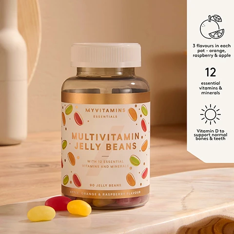 Image 1 - A clear bottle of Myvitamins Multivitamin Jelly Beans stands on a light wooden surface with a few loose jelly beans, its label showing Myvitamins Essentials Multivitamin Jelly Beans With 12 Essential Vitamins and Minerals 90 Jelly Beans Apple, Orange & Raspberry Flavour, and additional text noting 3 flavours in each pot - orange, raspberry & apple, 12 essential vitamins & minerals, and Vitamin D to support normal bones & teeth. Image 2 - A light peach square with rounded corners displays five white stars and a customer review that reads: What an amazing product, they taste exactly like the sweets but they have the added benefits of the vitamins! Its a no brainer, I will be choosing these over the sweets every time because they just taste so good! Verified Myvitamins Customer.
