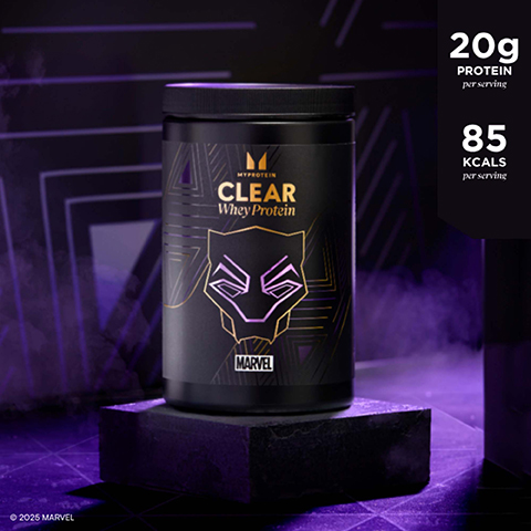 A black Myprotein Clear Whey Protein tub featuring a gold and purple Black Panther mask design is displayed on a black block against a dark purple, geometric background, with visible text including MYPROTEIN, CLEAR Whey Protein, MARVEL, 20g PROTEIN per serving, 85 KCALS per serving, and © 2025 MARVEL.