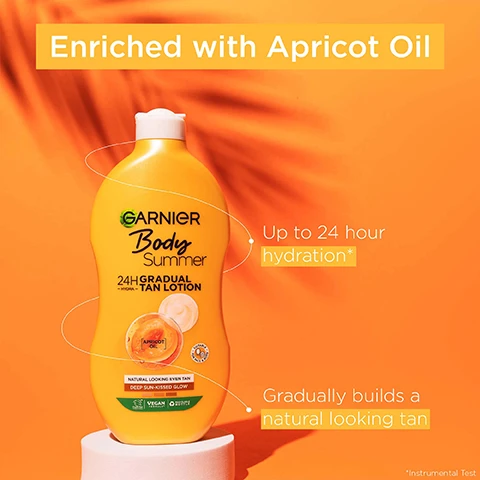 Image 1 - A yellow bottle of Garnier Body Summer 24H Gradual Tan Lotion is displayed on a white pedestal against an orange background, with text stating enriched with apricot oil, up to 24 hour hydration, and gradually builds a natural looking tan.
              Image 2 - A yellow bottle of Garnier Body Summer gradual tan lotion against an orange background, featuring text that reads Dermatologically Tested, Skin looks radiant & intensely nourished, Fast absorption, and Vegan formula, along with a small image of apricot oil.
              Image 3 - An upside-down yellow bottle of tanning lotion sits against an orange background, with the text No streaks and Deep sun-kissed glow visible.