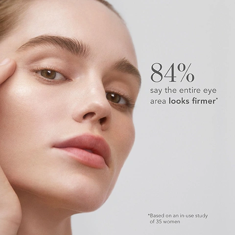 Image 3 - A close-up of a womans face with a glowing complexion, her hand gently touching her temple, next to the text 84% say the entire eye area looks firmer* *Based on an in-use study of 35 women.