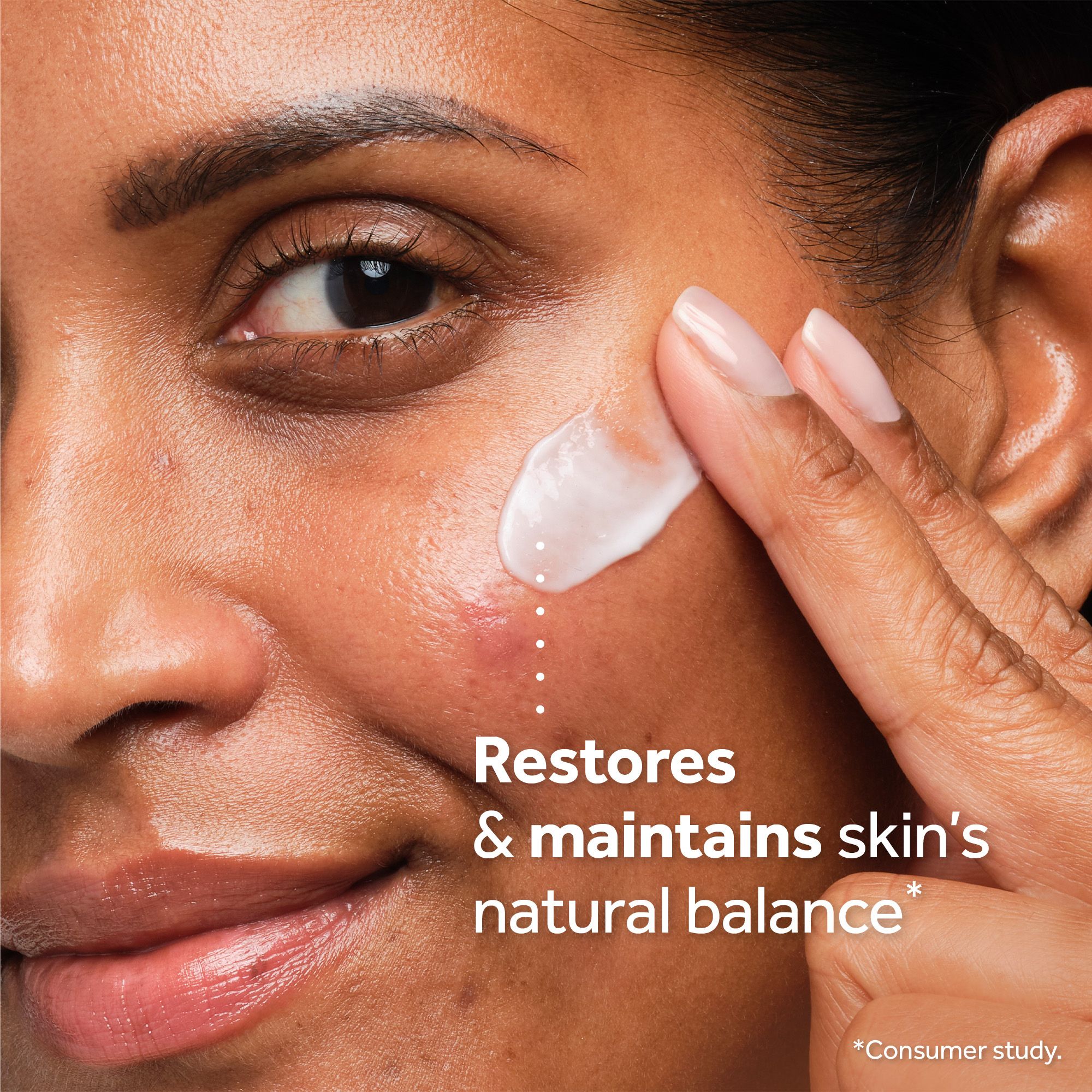Close up of a hand applying cream to a cheek with a blemish Restores & maintains skins natural balance *Consumer study.