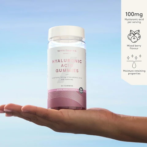 Image 2 - A hand holds a bottle labeled MYVITAMINS BEAUTY HYALURONIC ACID GUMMIES CONTAINS 100mg HYALURONIC ACID PER SERVING 60 GUMMIES MIXED BERRY FLAVOUR VEGAN FRIENDLY, with additional text to the side reading 100mg Hyaluronic acid per serving Mixed berry flavour Moisture retaining properties.
