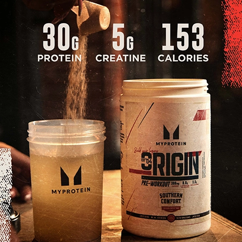 A person is pouring a scoop of powder into a clear container next to a white canister labeled MyProtein Origin with visible nutritional information that reads 30g protein, 5g creatine, and 153 calories.