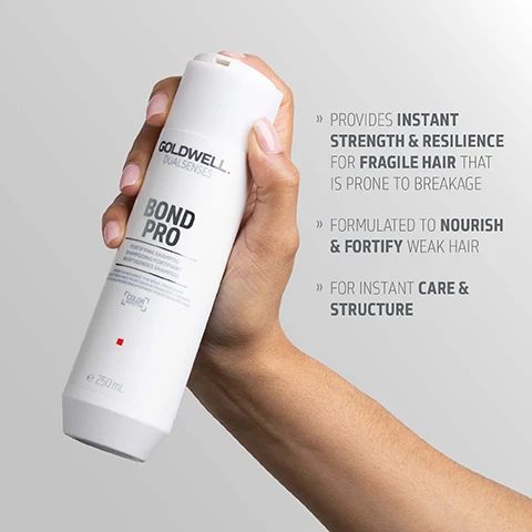 Image 1 - A hand holds a white bottle of Goldwell Dualsenses Bond Pro Fortifying Shampoo for fragile, weak hair, e 250mL, with text to the right listing benefits: PROVIDES INSTANT STRENGTH & RESILIENCE FOR FRAGILE HAIR THAT IS PRONE TO BREAKAGE, FORMULATED TO NOURISH & FORTIFY WEAK HAIR, FOR INSTANT CARE & STRUCTURE. Image 2 - A white bottle of Goldwell Dualsenses Bond Pro Fortifying Conditioner with a dollop of white product below it, accompanied by text describing the Microprotec Complex: Innovative technology distributes essential care ingredients quickly and evenly for instant results you can see and feel, and text on the bottle reads Goldwell Dualsenses Bond Pro Fortifying Conditioner Soin Fortifiant Kräftigender Conditioner Instant Resilience for Weak, Fragile Hair Résilience Instantanée pour Cheveux Fragiles et Cassants Sofortige Widerstandsfähigkeit für schwaches, brüchiges Haar Color Protection 200 mL. Image 3 - A white Goldwell Dualsenses Bond Pro Fortifying Shampoo bottle is displayed on a grey background with a dollop of white shampoo above it and two small drops below, featuring text on the bottle that reads Goldwell Dualsenses, Bond Pro, Fortifying Shampoo, Shampooing Fortifiant, Kräftigendes Shampoo, Strengthens hair and helps prevent breakage for weak, fragile hair, Color Protection, e 250 mL, and additional text on the right stating Microprotec Complex, Innovative technology distributes essential care ingredients quickly and evenly for instant results you can see and feel. Image 4 - A hand holds a white Goldwell Dualsenses Bond Pro conditioner bottle, with text reading Goldwell Dualsenses Bond Pro Fortifying Conditioner Soin Fortifiant Kraftigender Conditioner Instant & Resilience For Weak, Fragile Hair Pour Cheveux Fragilises & Abimes Für Strapaziertes, Brüchiges Haar Color Protection e 200 ml Visibly Reduces Hair Breakage For Instantly Stronger Hair. Image 5 - A white shampoo bottle is shown floating against a blue background, labeled GOLDWELL DUALSENSES BOND PRO FORTIFYING SHAMPOO SHAMPOOING FORTIFIANT KRÄFTIGENDES SHAMPOO, with a COLOR logo and 250 ML, alongside ClimatePartner certified product, climate-id.com/PBNVQ3, and CO2 measure reduce contribute logos. Image 6 - A white Goldwell Dualsenses Bond Pro Fortifying Conditioner bottle, e 200mL, floats against a blue background, with ClimatePartner certified product climate-id.com/PBNVQ3, a QR code, and CO2 measure reduce contribute text visible at the bottom.