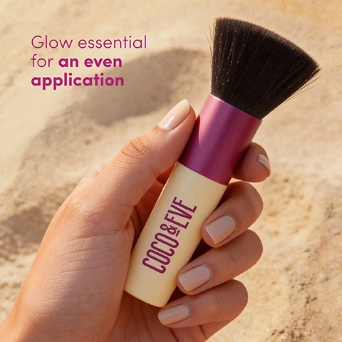 Image 1 - A hand with light nude nail polish holds a makeup brush with black bristles, a magenta band, and a cream-colored handle featuring the text COCO & EVE, against a blurred sandy background, with the overlay text Glow essential for an even application. Image 2 - Two Coco & Eve tanning brushes with black bristles, purple ferrules, and cream handles are crossed on a pink background, with text that reads Silky soft bristles Allows you to easily build up a natural-looking tan. Image 3 - A beige and pink makeup brush with black bristles lies reflected on a surface against a blue sky with clouds, with the text The finishing touch to your glow, Designed to blend tan seamlessly and COCO & EVE visible.