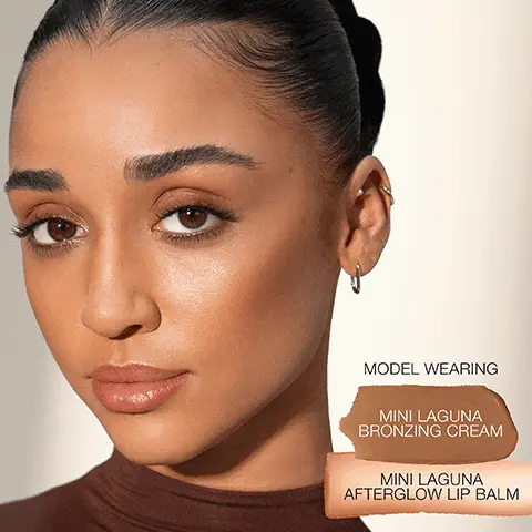 MODEL WEARING MINI LAGUNA BRONZING CREAM, MINI LAGUNA AFTERGLOW LIP BALM. MINI AFTERGLOW LIP BALM LAGUNA, MINI LAGUNA BRONZING CREAM LAGUNA 02 (ORIGINAL), MINI LAGUNA BRONZING POWDER LAGUNA 02 (ORIGINAL). MINIAFTERGLOW LIP BALM, Tinted balm saturates lips with a surge of hydration and sheer, subtle shine. MINI LAGUNA BRONZING CREAM, Decadently creamy formula seamlessly glides on for second-skin warmth. MINI LAGUNA BRONZING POWDER, Silky pigments deliver long-lasting warmth and effortlessly build lit-from-within bronze.