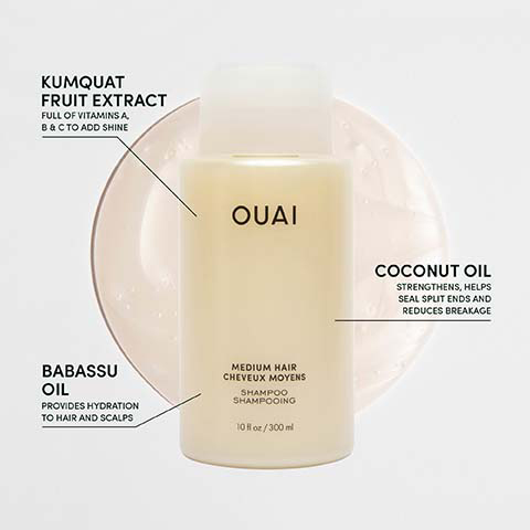 A light yellow Ouai shampoo bottle for medium hair is shown with text callouts indicating key ingredients and benefits: Kumquat Fruit Extract full of vitamins A, B & C to add shine, Babassu Oil provides hydration to hair and scalps, and Coconut Oil strengthens, helps seal split ends and reduces breakage, with the bottle also labeled as Shampoo Shampoing 10 fl oz / 300 ml.