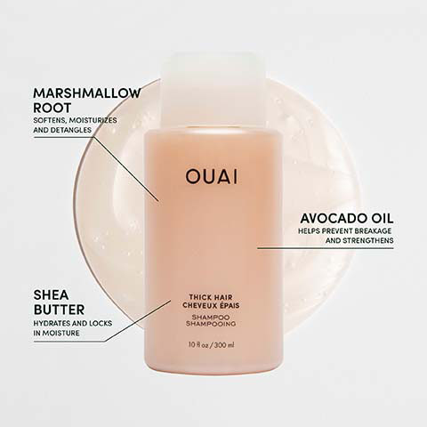 A light peach Ouai shampoo bottle is displayed with callouts detailing ingredients and benefits, including Ouai, Marshmallow Root softens, moisturizes and detangles, Avocado Oil helps prevent breakage and strengthens, Shea Butter hydrates and locks in moisture, Thick Hair Cheveux Épais, Shampoo Shampooing, and 10 fl oz / 300 ml.
