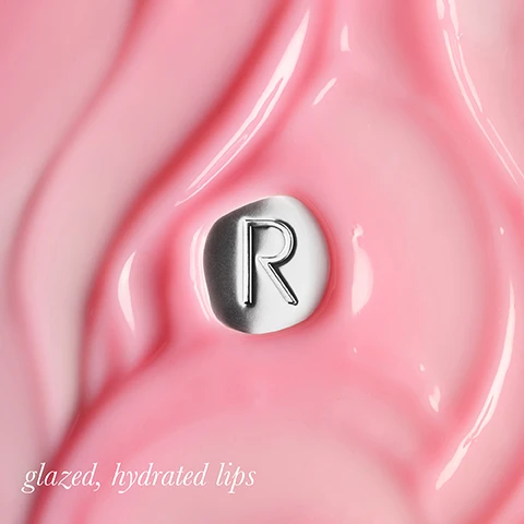 Image 1 - A shiny pink background with a silver circular emblem featuring the letter R, accompanied by the text glazed, hydrated lips.
              Image 2 - Image features a glossy red surface with a silver circular element marked with the letter R, accompanied by the text glazed, hydrated lips.
              Image 3 - A close-up image of glossy, pink lips with a silver circular emblem featuring the letter R on the surface, accompanied by the text glazed, hydrated lips.
              Image 4 - A woman with long, dark hair is holding a tube of Rodial Vegan Collagen skincare product near her face, showcasing her glowing skin; the image includes text that reads THE BENEFITS: Vegan Collagen infused formula to improve the look of lines Macadamia, hibiscus, jojoba, and sweet almond oils lock in moisture Antioxidant Cherry Oil.