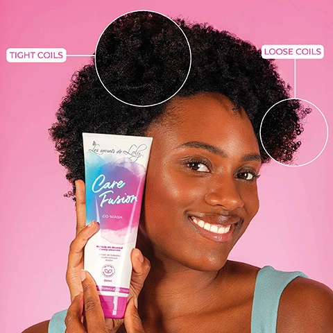 Image 1 - A woman smiles while holding a tube of Care Fusion co-wash in front of a pink background, with circles highlighting tight coils and loose coils in her hair. Les secrets de Loly is printed on the product.
              Image 2 - A tube of Care Fusion co-wash product is centered on a pink background with bubbles, and the visible text states 2-IN-1 CLEANSE & CARE, Nettoie en douceur, and 80% HYDRATED AND NOURISHED HAIR*.
              Image 3 - A tube of Care Fusion Co-Wash from Les secrets de Loly is displayed next to coconut halves, with text highlighting the benefits of babassu extract, lactic acid, and kaolin for hair care.
              Image 4 - A person holds a tube of hair co-wash labeled Care Fusion against a pink background, with text pointing out features like Gently Cleanses, Nourishes, and Scalp Protection, while the tube also includes 250ml and Nettoie en douceur.