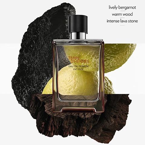 Image 1 - A perfume bottle labeled Terre dHermes Eau de Parfum Intense is placed on textured wood and surrounded by yellow citrus fruits and black volcanic rock, with the words lively bergamot, warm wood, and intense lava stone displayed nearby.
              Image 2 - A lineup of five perfume bottles labeled Terre dHermès, displayed on white pedestals, with visible text indicating the scent profiles for each: Terre dHermès Eau de Toilette (grapefruit, cedar, flint), Terre dHermès Eau Givrée (cedrat, juniper berry, Timut pepper), Terre dHermès Eau de Parfum Intense (lively bergamot, warm wood, intense lava stone), Terre dHermès Eau Intense Vétiver (green bergamot, Sichuan pepper, vetiver), and Terre dHermès Parfum (grapefruit, cedar, shiso).