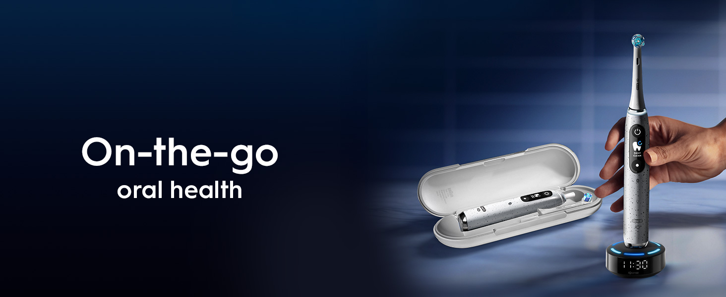 A hand holds a gray Oral-B electric toothbrush next to its open travel case and charging base displaying 11:30, with the text On-the-go oral health and DAILY CLEAN visible.