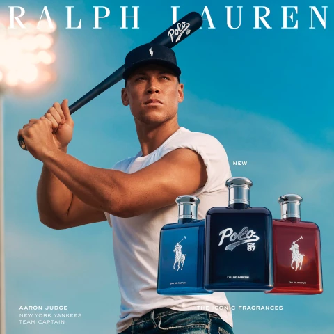 A muscular man in a white t-shirt holds a baseball bat, looking confidently into the distance against a blue sky; three perfume bottles with labels reading Polo are displayed in the foreground, and text at the bottom includes Aaron Judge, New York Yankees Team Captain and New.