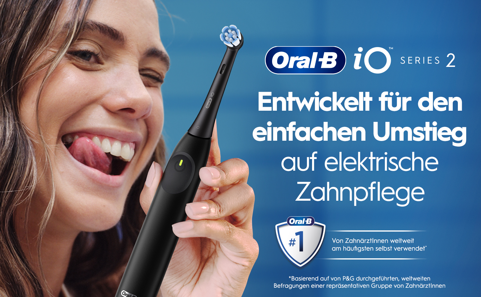 A smiling woman with long hair playfully sticking out her tongue holds an electric toothbrush against a blue background, with text that reads Oral-B iO Series 2 Entwickelt für den einfachen Umstieg auf elektrische Zahnpflege Oral-B #1 Von ZahnärztInnen weltweit am häufigsten selbst verwendet *Basierend auf von P&G durchgeführten, weltweiten Befragungen einer repräsentativen Gruppe von ZahnärztInnen.