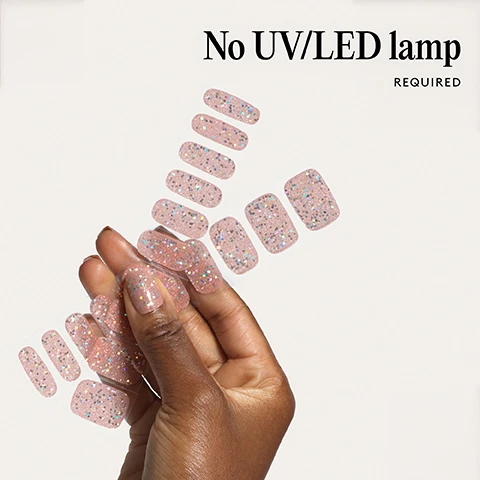 Image 1 - A hand holds a sheet of pink glitter nail polish strips No UV/LED lamp REQUIRED. Image 2 - Two nail tips with sheer pink polish and iridescent glitter, with the text 100% real salon-quality gel. Image 3 - Close-up of a persons face and hand with light pink glitter nails Lasts up to 14 days. Image 4 - Close-up of a hand with nails painted light pink with silver glitter, with the text 1 minute removal NO DAMAGE. Image 5 - An infographic showing four steps with illustrations and text instructions for applying nail wraps, titled Step by step 01 PREP Use a Wooden Cuticle Stick to gently push back your cuticles and buff the shine off your nail plates with a 240 grit nail file. Cleanse each nail using a Lint Free Wipe soaked in Prep & Wipe to remove any oils - this helps the wraps adhere better and last longer. If you dont have these products, washing your hands is a good alternative. If your nails are naturally oily, apply Nail Dehydrator as an extra step after cleansing. 02 STICK & WRAP Choose your favourite design and select the right width wrap for each nail - if youre between sizes, go slightly smaller. Peel the wrap from the sheet, touching only the end that wont go on the nail. Apply the wrap as close to the cuticle as possible without touching the skin. Press the wrap firmly from the centre outwards to avoid air bubbles. Use your thumb to press down and seal the edges. 03 TRIM & FILE Trim any excess as close to your nail length as possible using Curved Edged Scissors. After trimming, press the wrap firmly over the free edge of the nail, then file in only one direction, from top to bottom, using a 180 grit nail file. Lightly file underneath the free edge to remove excess and align the edges. Finish by pressing down again to fully seal the wrap in place. Avoid applying any oils or getting your hands wet for at least 2 hours after application to ensure maximum adhesion. Then youre set for up to 14 days! 04 REMOVE Quick, damage-free removal in just 1 minute. Apply Mylee Wrap Remover Oil around the edges of the wrap. Gently lift one side with a Wooden Cuticle Stick and slowly slide it underneath, adding more oil as needed. Once removed, wipe your nails and wash your hands. Image 6 - Image shows a list of bullet points next to red nail stickers with text that says Easiest and gentlest mani in the world Lasts up to 14 days Fast & gentle 1-min removal Fully-cured - No LED Lamp required Comes in 10 sizes Long-lasting shine and chip-resistant Quick and easy application Hema-free, vegan, and cruelty-free Pre-cut and ready to go!
