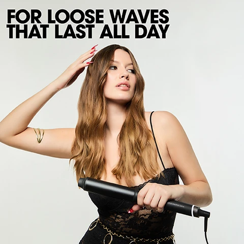 Image 1 - A woman with wavy hair holds a black curling iron with the text FOR LOOSE WAVES THAT LAST ALL DAY above her. Image 2 - A black GHD curling wand is shown next to text describing its features GHD MAX WAND For loose waves that last all day 65% bigger barrel for 3x faster, high-definition results for easy, frizz-free curls that last all day HD FRIZZ FREE CURLS CURL RESPONSIVE TECHNOLOGY UP TO 3X FASTER CURLS. Image 3 - Dark hair is wrapped around a curling iron barrel with the text FLAT WRAP THE HAIR AROUND THE BARREL AND HOLD FOR 3-5 SECONDS. Image 4 - A woman with long dark hair wears a black blazer on a white background with text reading IDEAL FOR LONG & VERY LONG HAIR. Image 5 - A split image shows a woman with wavy hair next to hair products and a styling tool, with text reading CURLY EVER AFTER and CURLS GONE WILD. Image 6 - Four black ghd curling tools are shown against a black background above the text GHDS CERAMIC HEATER ENSURES THE OPTIMUM TEMP OF 185°C IS MAINTAINED ACROSS THE BARREL.