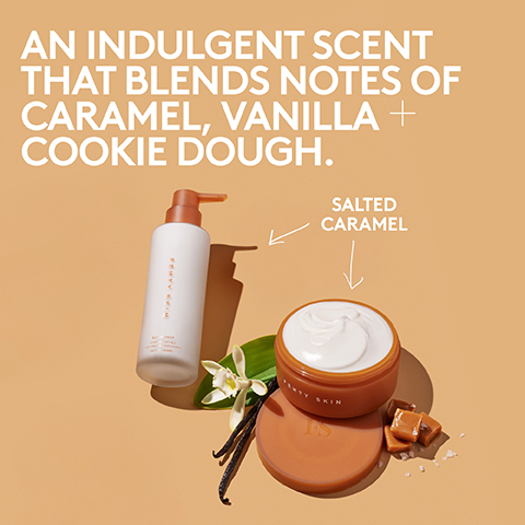 A white pump bottle and an open jar of cream, both Fenty Skin products, are displayed on an orange background alongside a vanilla flower, vanilla beans, and caramel candies, with the visible text An indulgent scent that blends notes of caramel, vanilla + cookie dough and Salted Caramel.