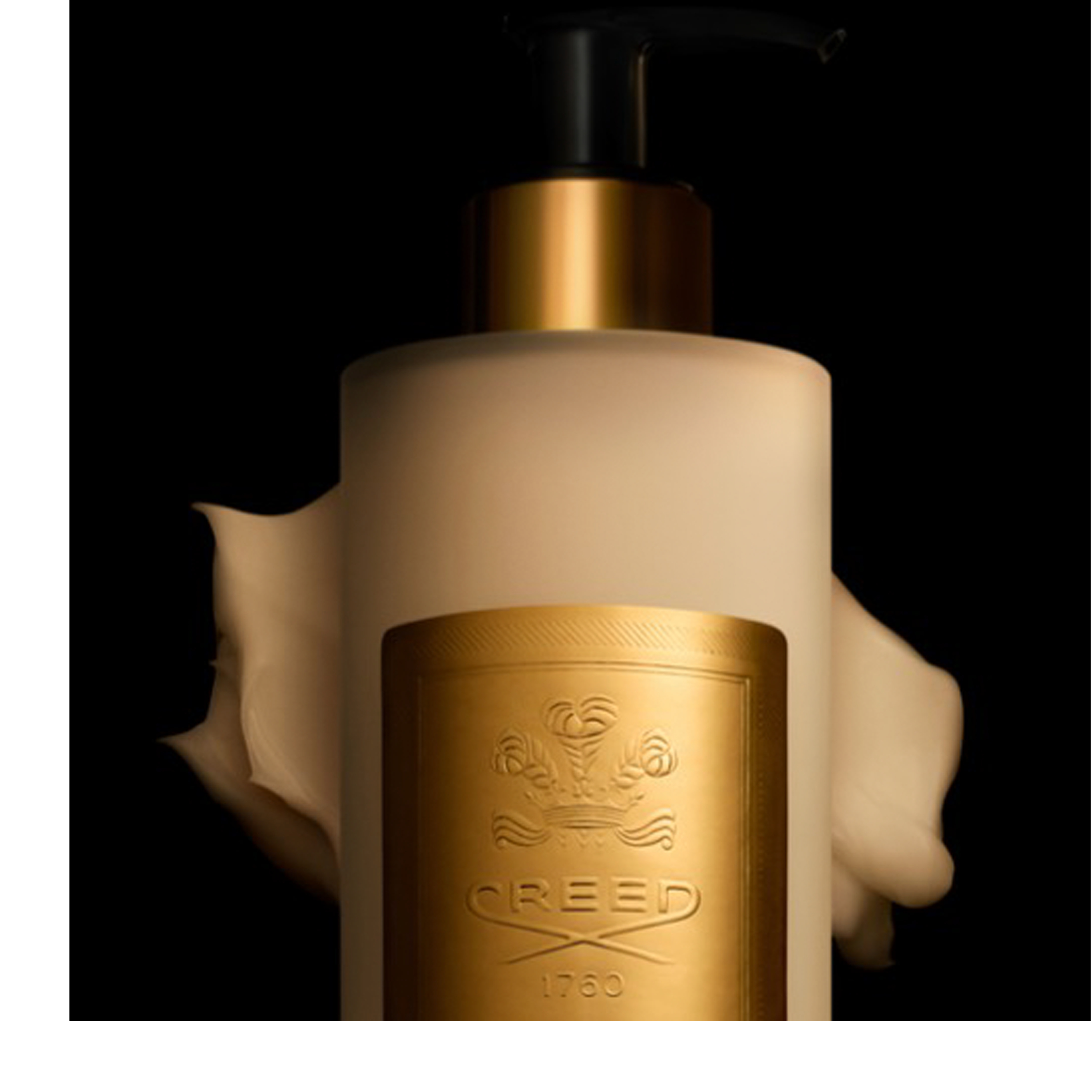 A light-colored lotion bottle with a black pump and gold collar has a swirl of cream on its left side, featuring a gold label with an ornate crest and the text CREED 1760.
